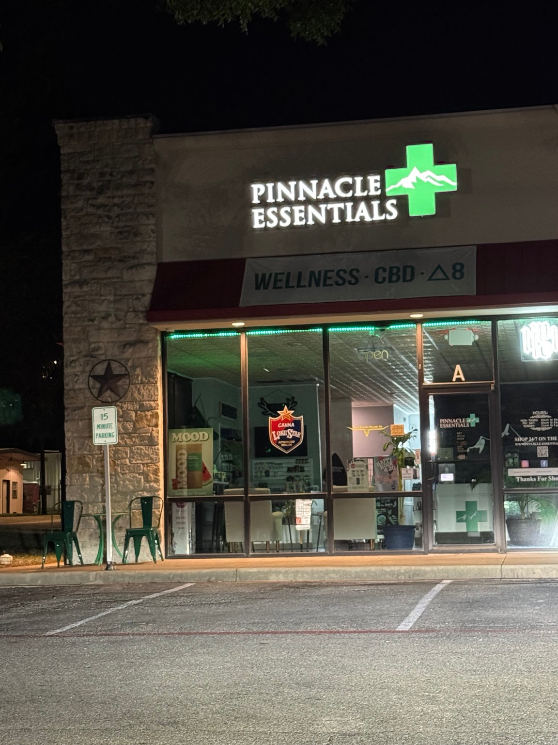 Pinnacle Essentials illuminated storefront at night