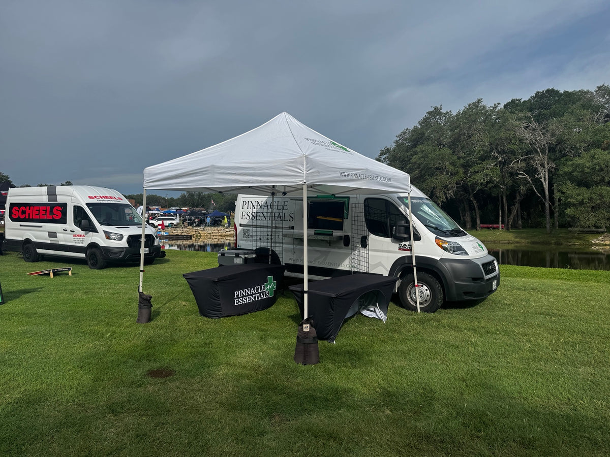 Pinnacle Essentials van and canopy set up at an outdoor event