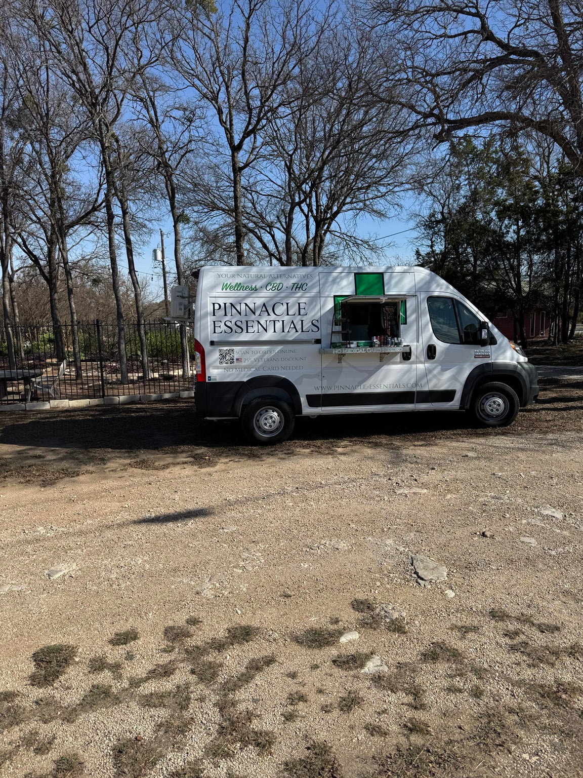 Side view of the Pinnacle Essentials van at a wooded venue